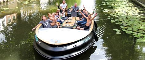 Foto van een lachende groep die geniet van een boottocht door de grachten van Volendam.