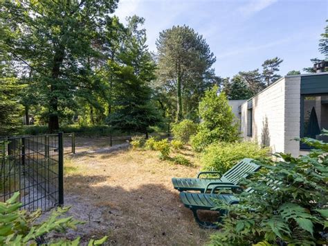 Plattegrond van een hondenbungalow met omheinde tuin en voorzieningen zoals mand, bench en voerbakken