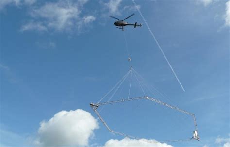 Helikopter met meetinstrument boven landschap