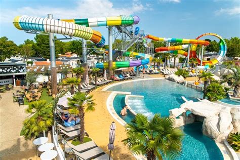 Een dynamische foto van het waterpark van Camping Club MS Les Tamaris met glijbanen en zwembaden.