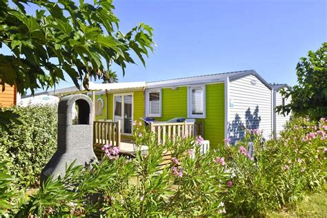 Een sfeervolle foto van Camping Sandaya Les Tamaris met groen aangelegde percelen en het dorpsachtige karakter.