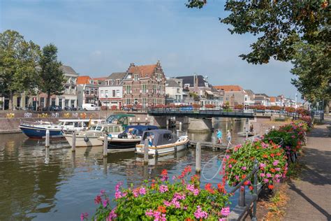 Gezicht op de Lingehaven met historische pakhuizen en molens in Gorinchem