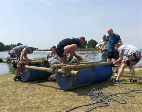 Groep mensen die vlotten bouwt aan het water