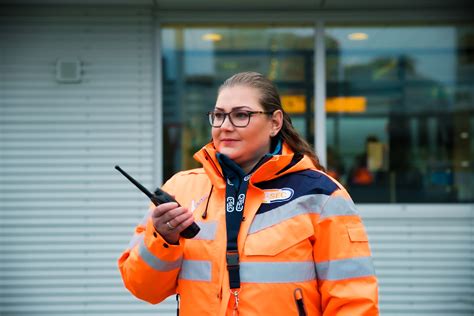 Foto van een vriendelijke beveiligingsmedewerker die passagiers helpt bij de security controle.