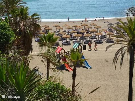 Zonnig strand met ligbedden en parasols aan de kust van Andalusië
