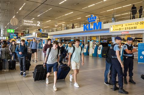 illustratie van een vertrekhal op Schiphol met mensen die geëvacueerd worden