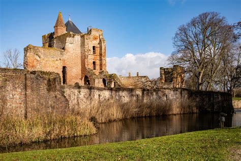 Landschapsfoto van de ruïne van Huis Hemmen, gelegen in een parkachtige omgeving.