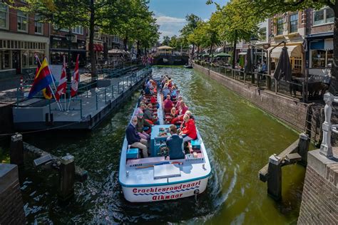 Een rondvaartboot met glazen dak vaart door de grachten van Groningen.